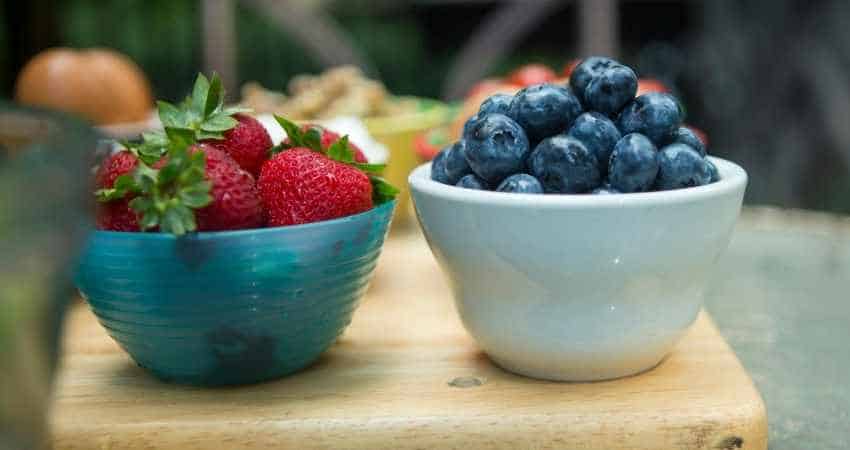a bowl of blueberries and a bowl of strawberries.