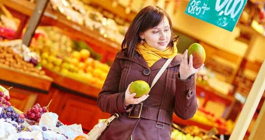 Choosing mangoes at the store.