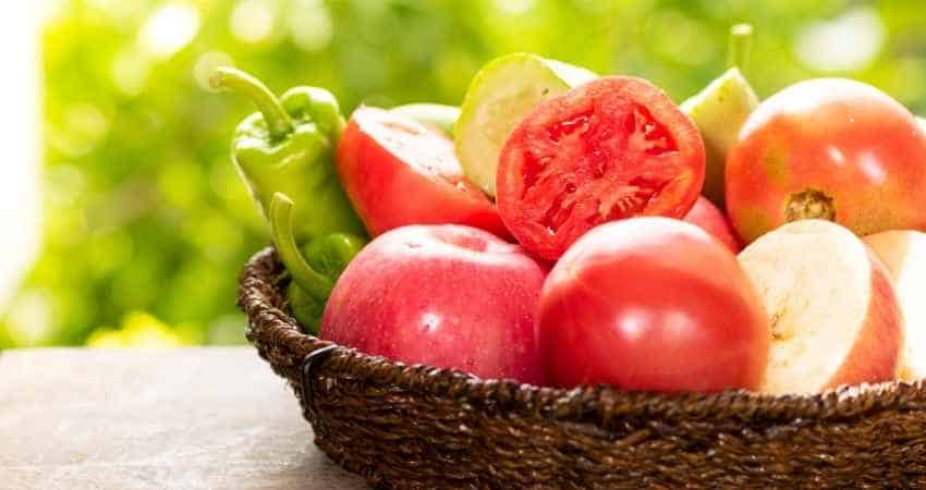 tomatoes and other food in a basket.