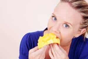 a woman eating a mango.