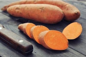 sweet potatoes and russet potatoes on a cutting board