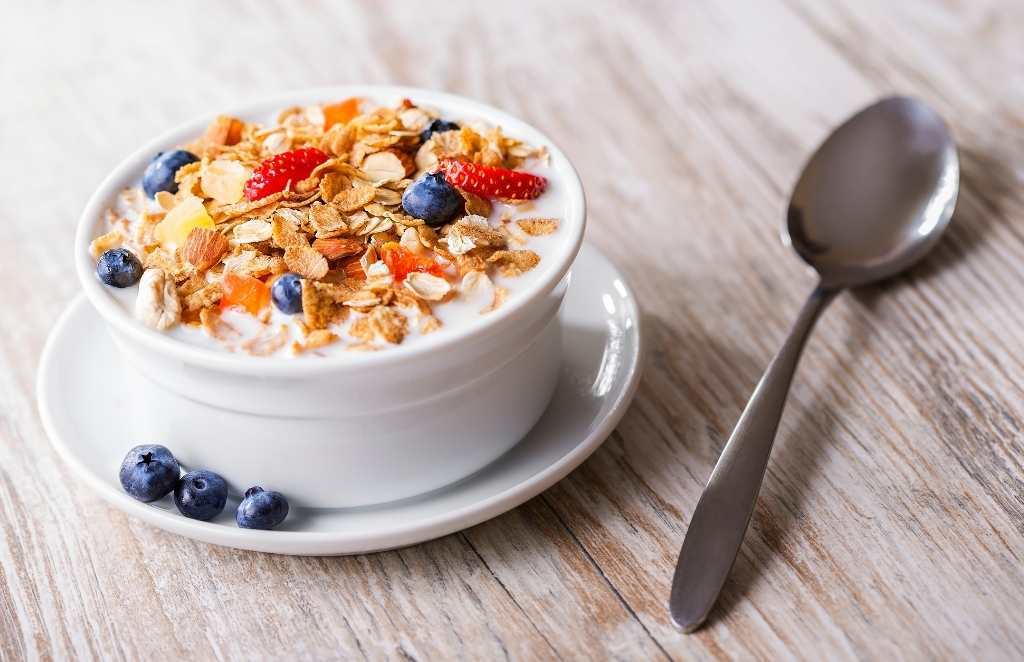 a bowl of muesli with fruit and milk