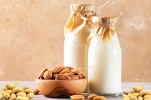 almond milk in bottles and almonds on the side