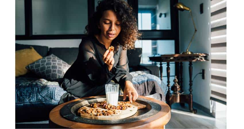 Woman with celiac disease snacking on almonds with almond milk