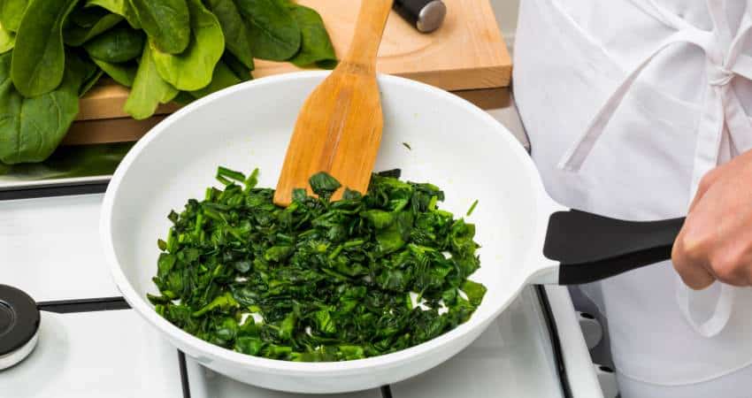 Cooking chopped spinach.