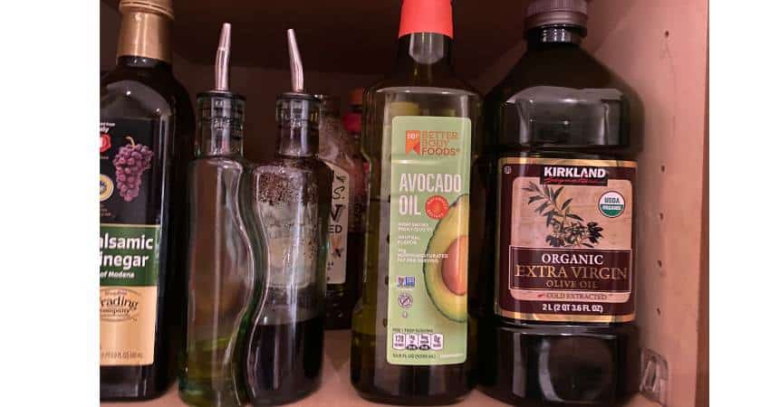 Olive oil and avocado oil stored in Kevin Garce's cabinet at home.
