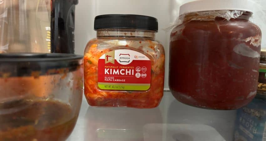 Kimchi inside my refrigerator in a sealed jar with plastic to help with the smell.
