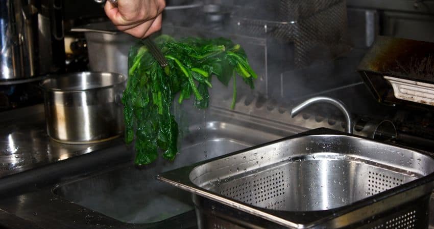 Blanching spinach in a restaurant.
